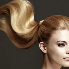 Ein voluminöser, goldblonder Pferdeschwanz, der elegant über die Schulter fällt. Perfekt für festliche pferdeschwanz frisuren.