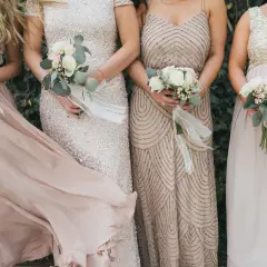 Brautjungfern in eleganten Kleidern mit Blumensträußen, perfekt für einen dresscode boho hochzeit.
