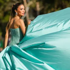 Elegante Frau in einem mintgrünen, bestickten Kleid mit weitem Rock, der im Wind weht. Ein Hauch von Glamour, der an einen **black tie** Event erinnert.