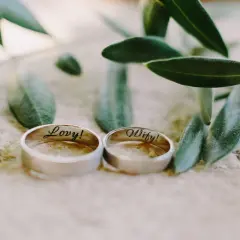 Zwei Ringe, "Lovy!" und "Wify!", liegen neben Olivenzweigen. Ein schönes Symbol für den 29. Hochzeitstag.