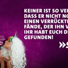 Ein Mann mit Einhornmaske küsst eine Frau mit Einhorn-Haarreif. Ein lustig-witziges Bild, das perfekt zum Hochzeitstag passt!