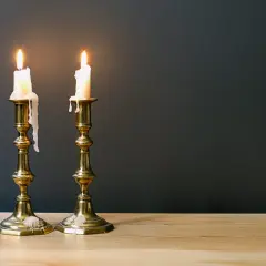 Zwei brennende Kerzen auf Messing-Leuchtern, die die Bedeutung des 45. Hochzeitstages symbolisieren: ein langes, gemeinsames Leben.