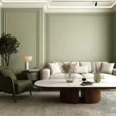 Ein stilvolles japandi style wohnzimmer mit einem beigen Sofa, einem grünen Sessel, einem ovalen Couchtisch und einem abstrakten Bild.