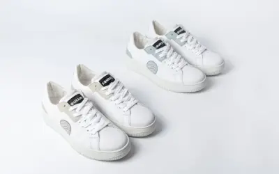 Zwei Paar weiße trend sneaker mit hellgrauen und mintgrünen Akzenten, auf weißem Hintergrund.
