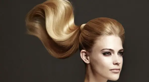 Ein voluminöser, goldblonder Pferdeschwanz, der elegant über die Schulter fällt. Perfekt für festliche pferdeschwanz frisuren.
