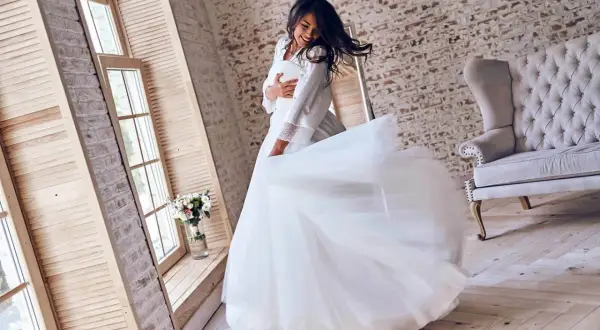 Glückliche Braut dreht sich in ihrem Traumkleid. Hier finden Sie günstige brautkleider online, um Ihren großen Tag perfekt zu machen.