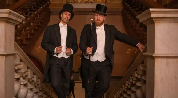 Zwei Herren im eleganten Frack mit Zylinder und Gehstock, ein perfektes Beispiel für den Dresscode Herren für einen besonderen Anlass.