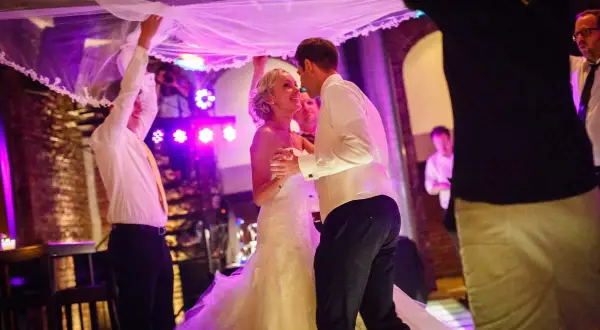 Brautpaar tanzt unter dem Brautschleier, ein romantischer Schleiertanz bei der Hochzeit.