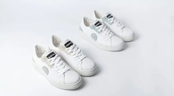 Zwei Paar weiße trend sneaker mit hellgrauen und mintgrünen Akzenten, auf weißem Hintergrund.