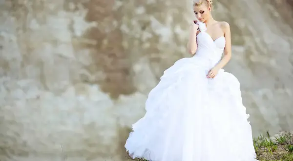 Braut in weißem Kleid mit voluminösem Reifrock, bereit, "Ja" zu sagen. Ein Traum, wenn Sie einen Reifrock kaufen möchten.