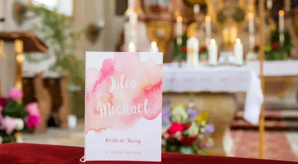 Hochzeitsprogramm für Julia & Michael. Im Hintergrund der Kirche erklingen bekannte kirchenlieder zum Mitsingen.
