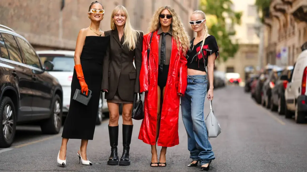 Vier Frauen präsentieren unterschiedliche **dresscodes Frauen**: von elegantem Schwarz über lässige Jeans bis hin zu auffälligem Rot.