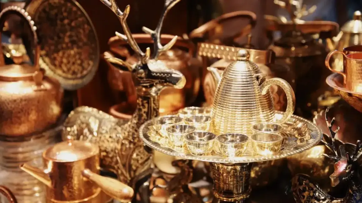 Glänzende bronzene Teekanne mit Tassen und Hirschfigur, perfekt für eine bronzene Hochzeit.