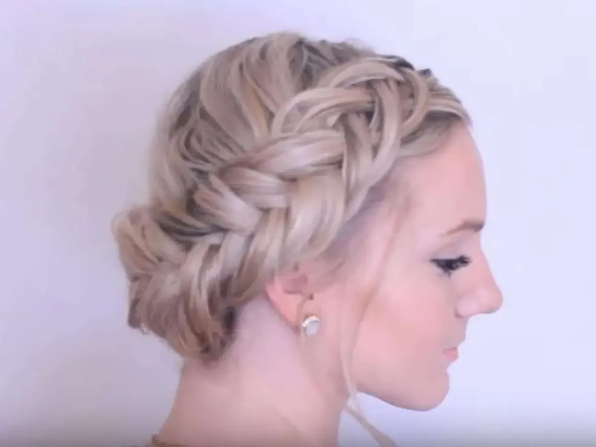 Wiesn Frisur kurze Haare: Ein geflochtener Kranz um den Kopf, der wie ein Haarband wirkt, mit einem Dutt im Nacken.
