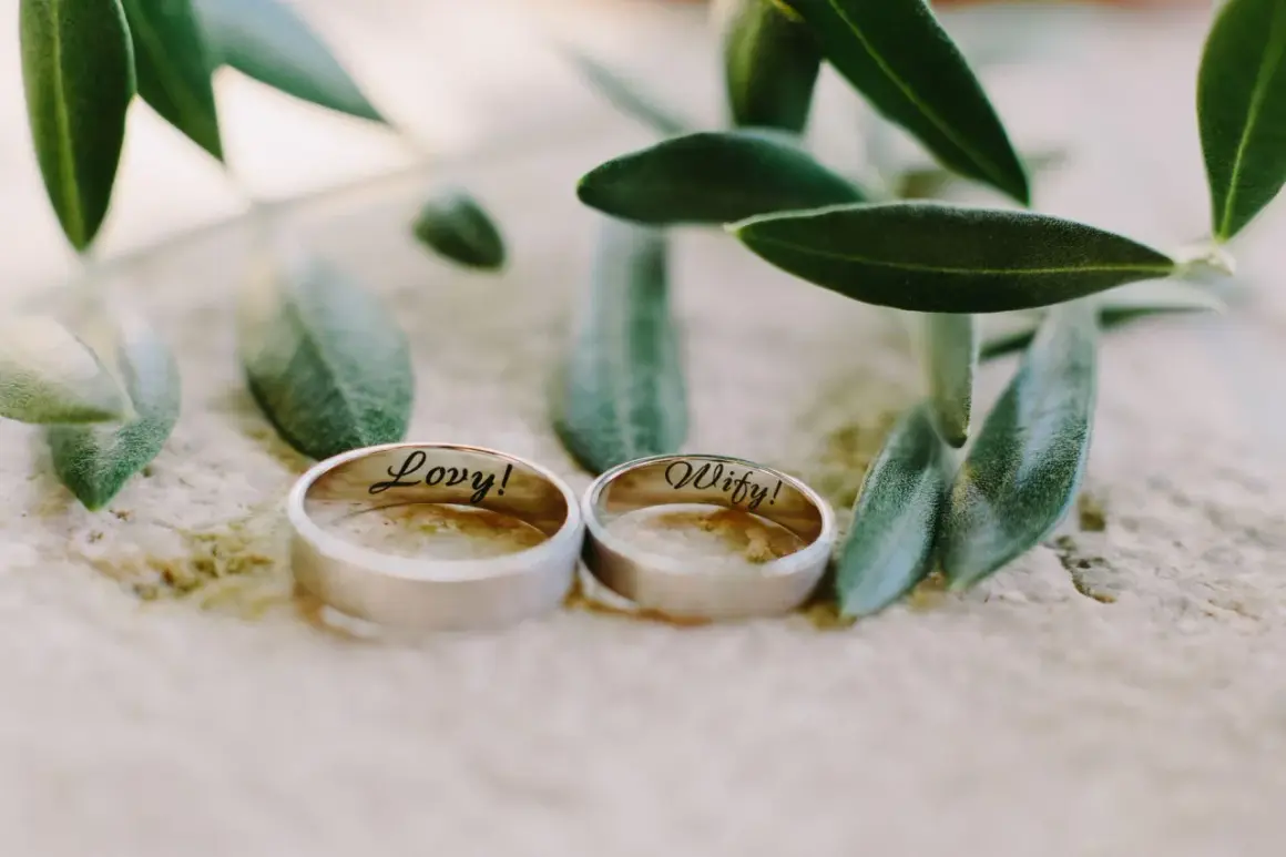 Zwei Ringe, "Lovy!" und "Wify!", liegen neben Olivenzweigen. Ein schönes Symbol für den 29. Hochzeitstag.
