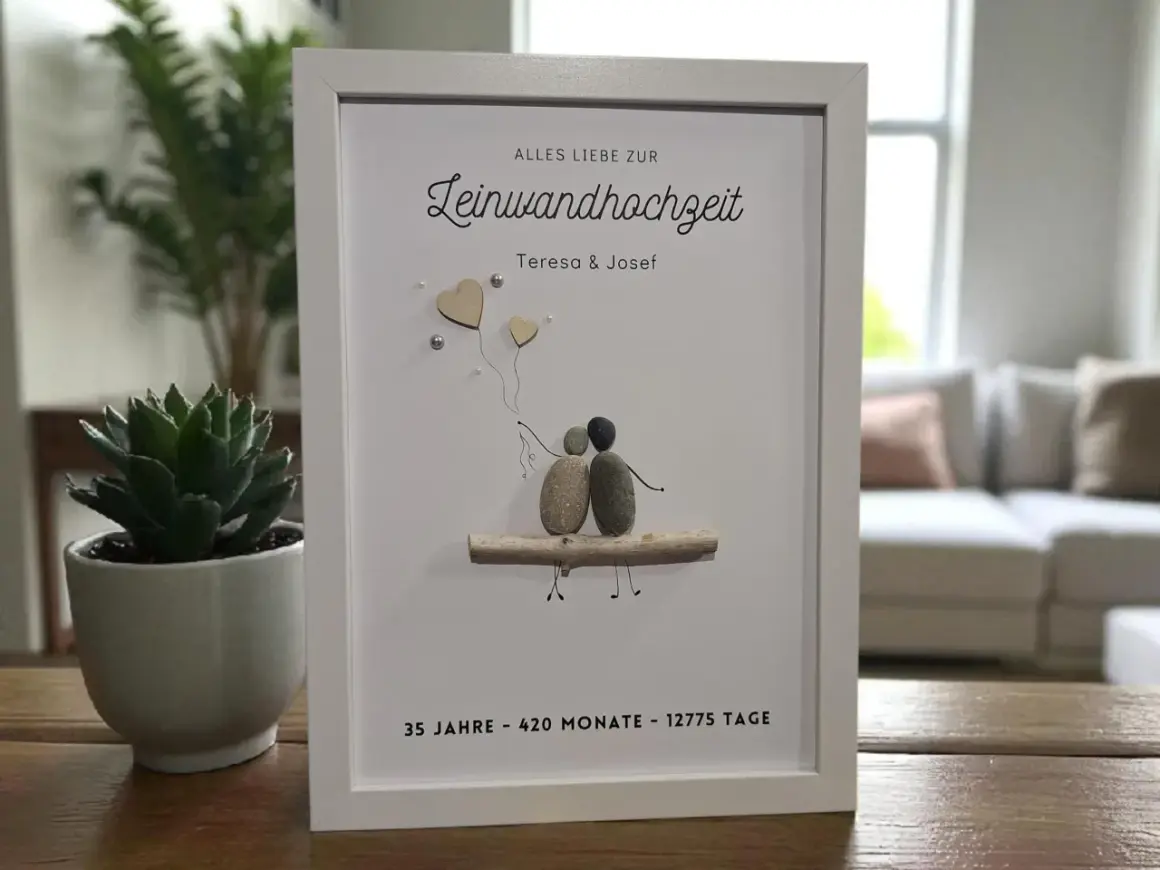 Gerahmtes Bild mit Steinfiguren eines Paares, das auf einem Ast sitzt. Es feiert den 35. Hochzeitstag von Teresa & Josef.