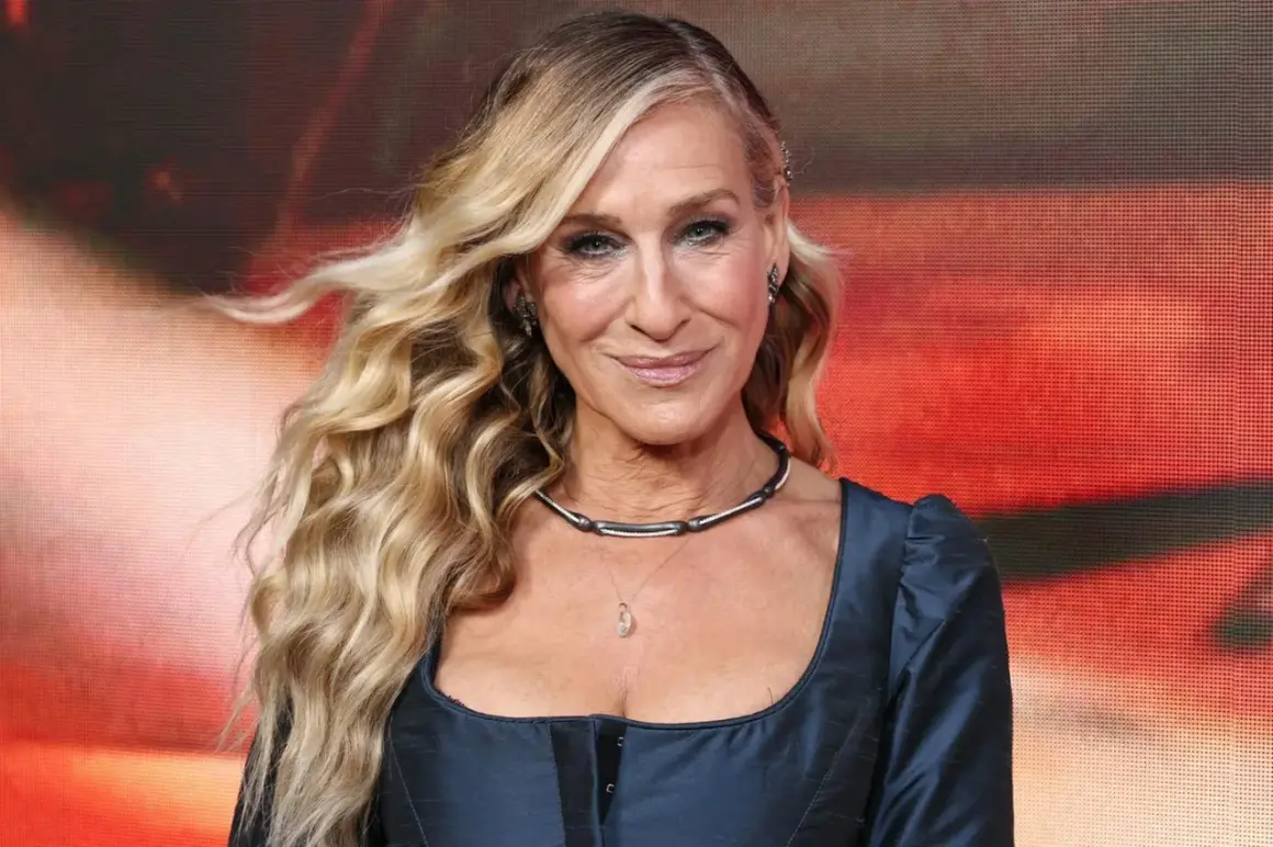 Sarah Jessica Parker mit ihrem charakteristischen beach waves bob, lächelnd in einem dunkelblauen Kleid.
