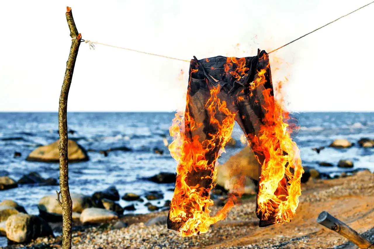 Jeans in Flammen am Strand, ein Symbol f&uuml;r den Polterabend, bei dem die alte Hose verbrannt wird.
