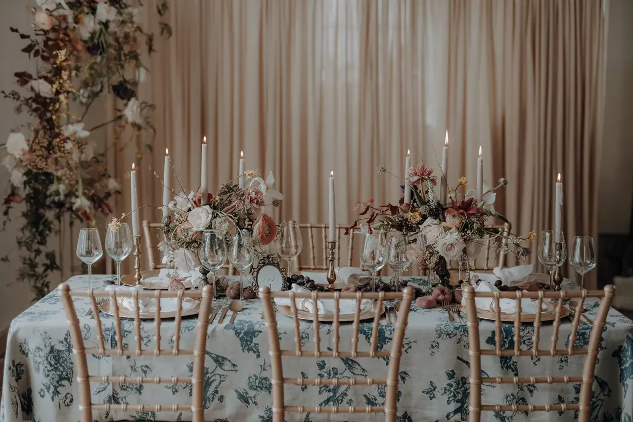 Festlich gedeckter Tisch mit Blumenarrangements, Kerzen und Wein-Gläsern. Originelle Ideen Hochzeit für ein romantisches Ambiente.