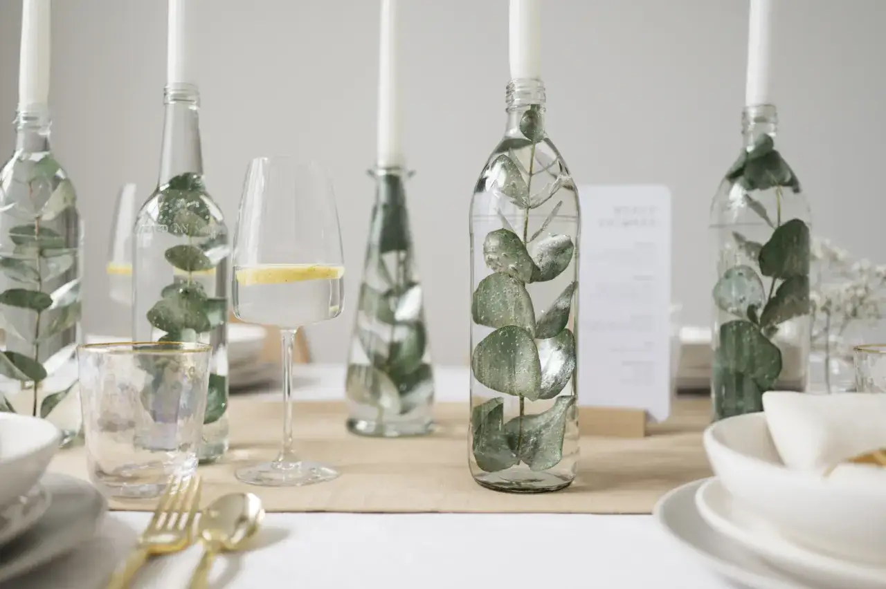 Eukalyptus-Zweige in Flaschen als Kerzenhalter und Wassergl&auml;ser mit Zitronenscheiben &ndash; eine stilvolle Idee f&uuml;r eine low budget hochzeit.