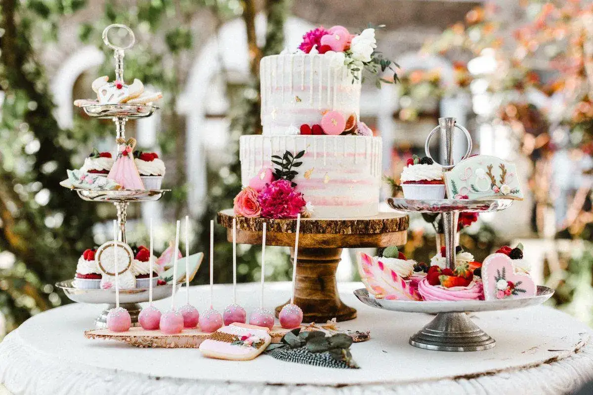 Festliche Hochzeitstafel mit zweistöckiger Torte, Cupcakes, Cake Pops und Keksen. Muffins hochzeit sind ein süßer Traum.
