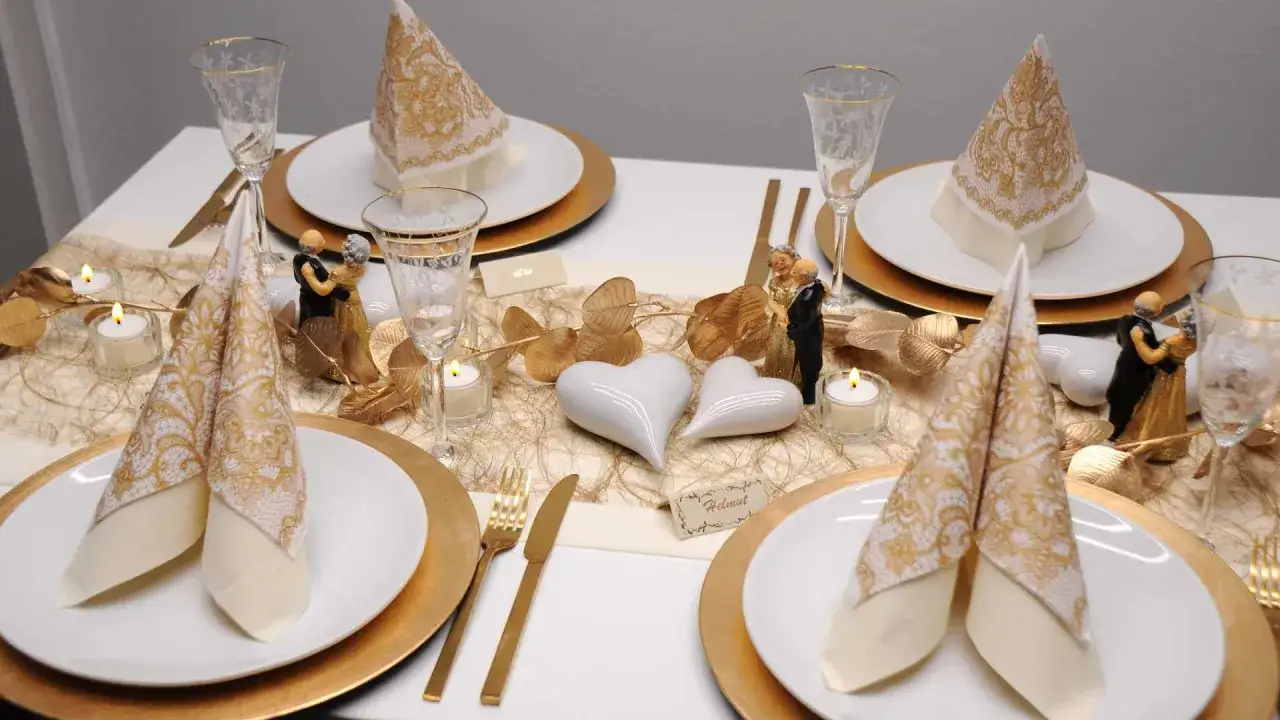 Festlich gedeckter Tisch mit goldenen Akzenten, Kerzen und Figuren eines tanzenden Paares. Ein Symbol für die Bedeutung eines 75. Hochzeitstages.