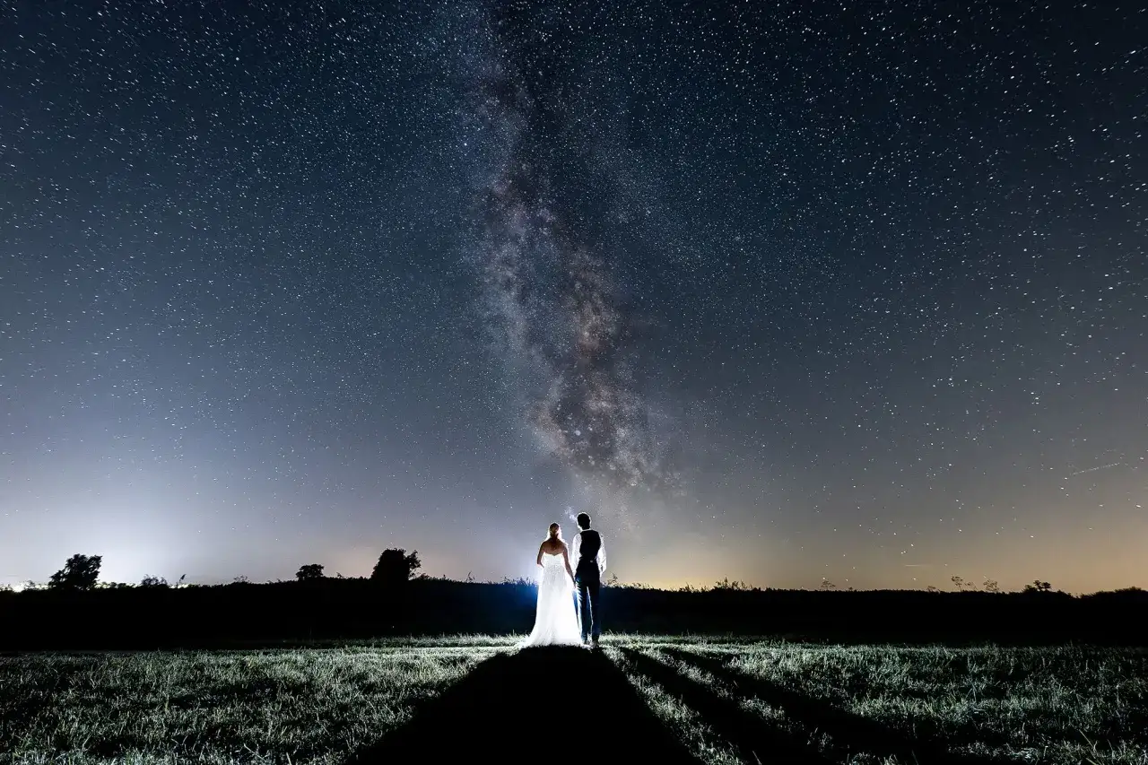 Ein Brautpaar steht unter dem Sternenhimmel. Die Milchstra&szlig;e leuchtet. Ein sch&ouml;ner Anblick, der die Bedeutung eines 44. Hochzeitstages widerspiegelt: Liebe, die ewig w&auml;hrt.