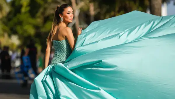 Elegante Frau in einem mintgrünen, bestickten Kleid mit weitem Rock, der im Wind weht. Ein Hauch von Glamour, der an einen **black tie** Event erinnert.