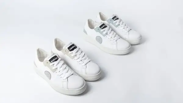 Zwei Paar weiße trend sneaker mit hellgrauen und mintgrünen Akzenten, auf weißem Hintergrund.