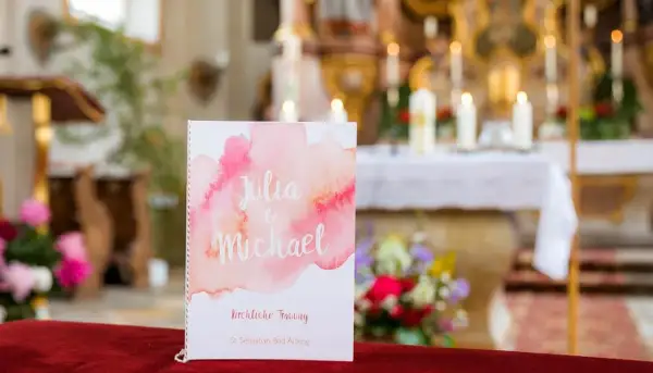 Hochzeitsprogramm für Julia & Michael. Im Hintergrund der Kirche erklingen bekannte kirchenlieder zum Mitsingen.