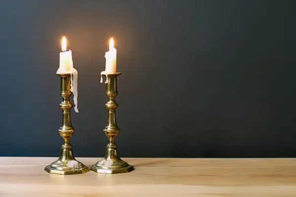 Zwei brennende Kerzen auf Messing-Leuchtern, die die Bedeutung des 45. Hochzeitstages symbolisieren: ein langes, gemeinsames Leben.